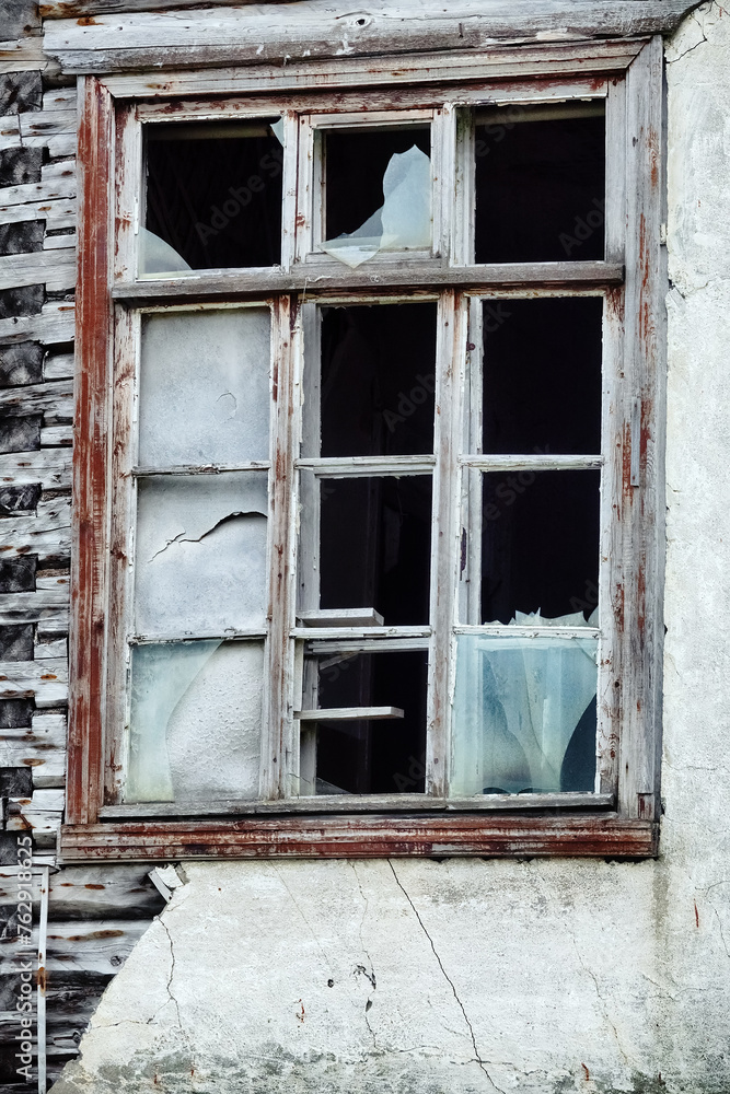 The seaside house has long been abandoned. An old ruined window in house on sea of Arctic Ocean