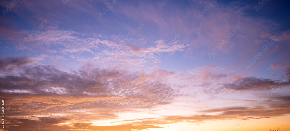 Sunset or sunrise. Dramatic majestic scenery sunset. Sky with clouds in sunset sky light background. Sunrise with clouds in various shapes. Calm sunset sky and sun through clouds over.