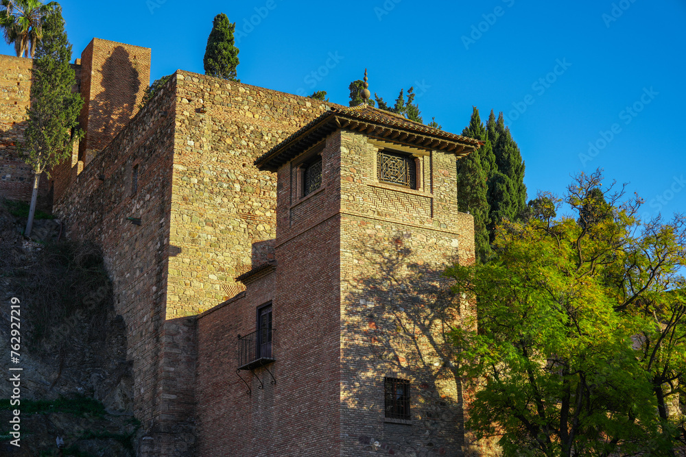 Tower and imposing stone walls of the Alcazaba Palace in Malaga Tower and imposing stone walls of the Alcazaba Palace in Malaga