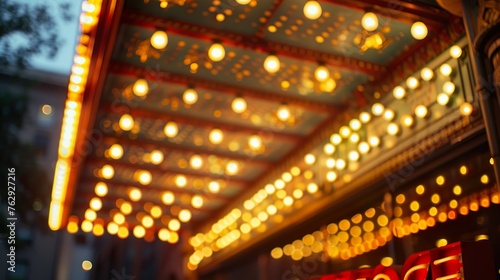 A historic theater's marquee illuminated with light © Photock Agency