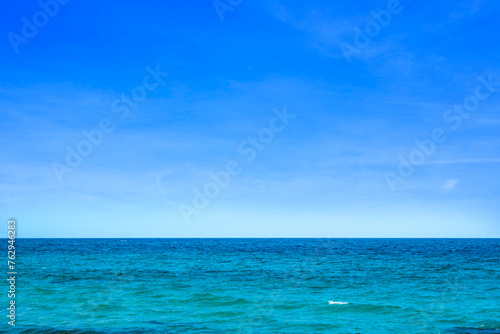 Ocean background and sea water and clear sky. For summer vacation ideas The nature of the beach and summer sea with the sun shining on the sea sparkling against the blue sky. 