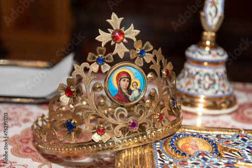 The golden crown with the Virgin Mary that is placed on the groom's head in the Orthodox church at the wedding ceremony IN Romania © Laurenx