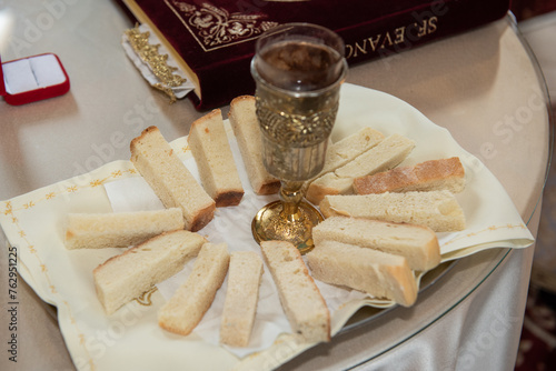 consecrated bread into the consecrated wine  in Romania © Laurenx