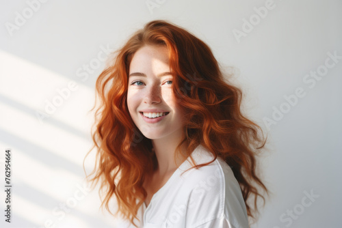 A woman with red hair is smiling and posing for a picture