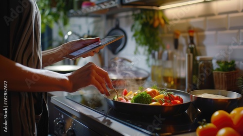 Woman following recipe cooking healthy food online with tablet at kitchen. photo