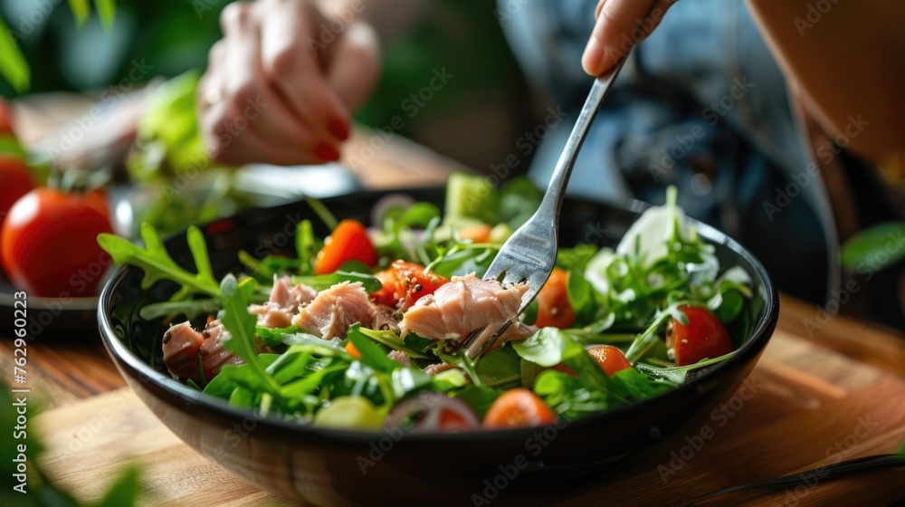 Person eating healthy salmon salad with fresh vegetables. Person eating healthy salmon salad with fresh vegetables.