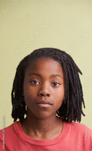African boy, portrait and fashion in studio with creative, style and confidence on a yellow background. Face of young and cool model, student or teenager in natural hair and casual or trendy t shirt