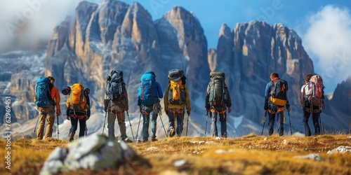 A group of people are standing on a mountain, all wearing backpacks
