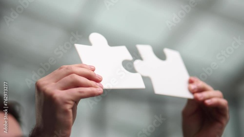 Close up hands pieces of white puzzle, assemble jigsaw, put it together, joint path to problem solution photo