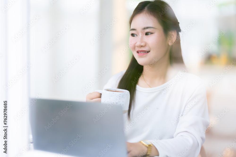 Happy of asian freelance people business female casual working with laptop computer and holding a coffee and smartphone in coffee shop like the background,communication concept Happy of asian freelance people business female casual working with laptop computer and holding a coffee and smartphone in coffee shop like the background,communication concept