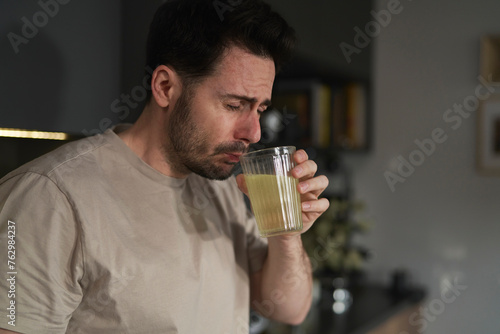 Man drinking electrolytes in the kitchen photo