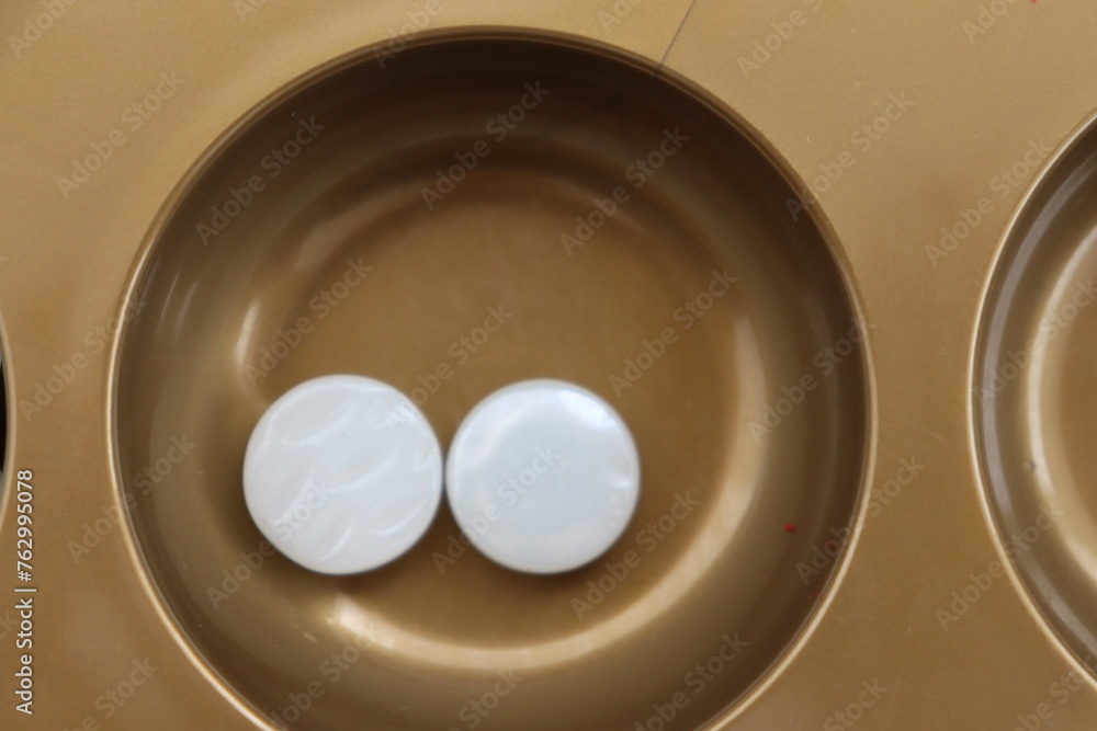 Mangala game with board and marbles set up on a table Mangala game with board and marbles set up on a table