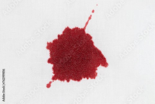 Drops of blood stains on white fabric. blood splatters on clothes. red dripping blood spatters