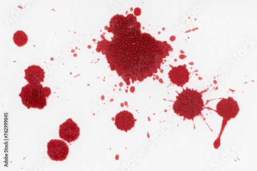 Drops of blood stains on white fabric. blood splatters on clothes. red dripping blood spatters