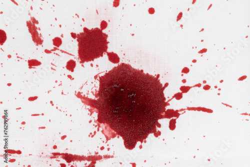 Drops of blood stains on white fabric. blood splatters on clothes. red dripping blood spatters photo