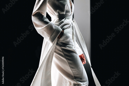 Trendy stylish fashion details of a long white coat and pants. Women's Casual Fashion. Side view