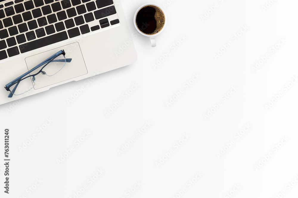 Office desk or workspace with laptop computer,cup of coffee and glasses Office desk or workspace with laptop computer,cup of coffee and glasses