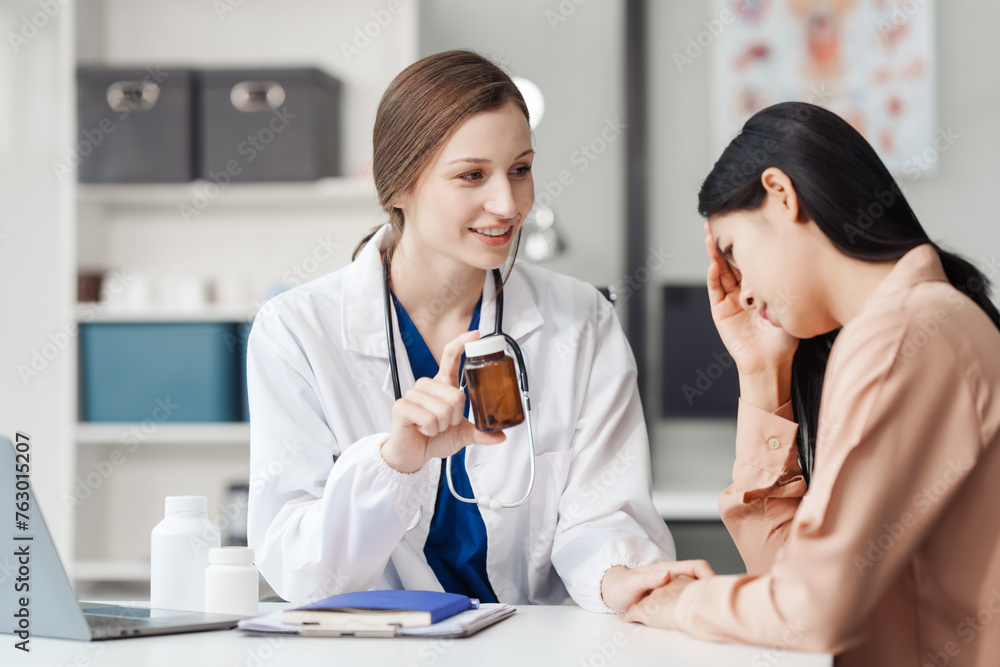 Attractive female Caucasian female doctor and psychologist gives advice, encouragement to female Asian patients. from depression in hospital examination room. cognitive behavioral therapy CBT Attractive female Caucasian female doctor and psychologist gives advice, encouragement to female Asian patients. from depression in hospital examination room. cognitive behavioral therapy CBT