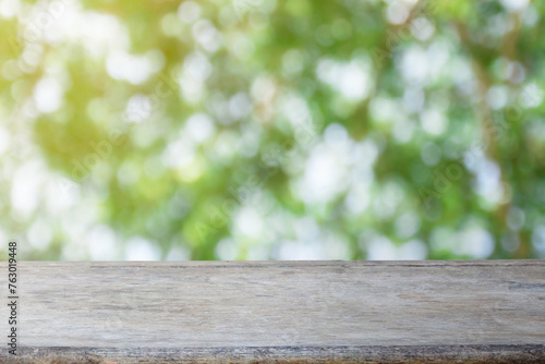 Wood table top on blur abstract green bokeh in the morning background