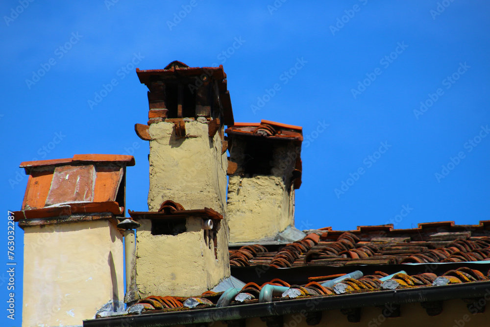 Fototapeta premium Chimneys of a historic house in the old town of Siena, Tuscany, Italy