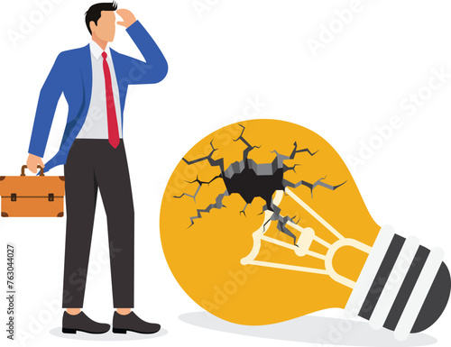 Businessman is disappointed with an broken idea light bulb on ground -