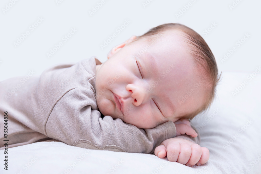 newborn sleeping baby on belly on light background, close-up, lifestyle, purity and innocence concept. newborn sleeping baby on belly on light background, close-up, lifestyle, purity and innocence concept.