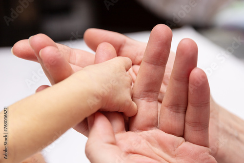 Newborn baby holds mother's hand. selective focus © Iryna