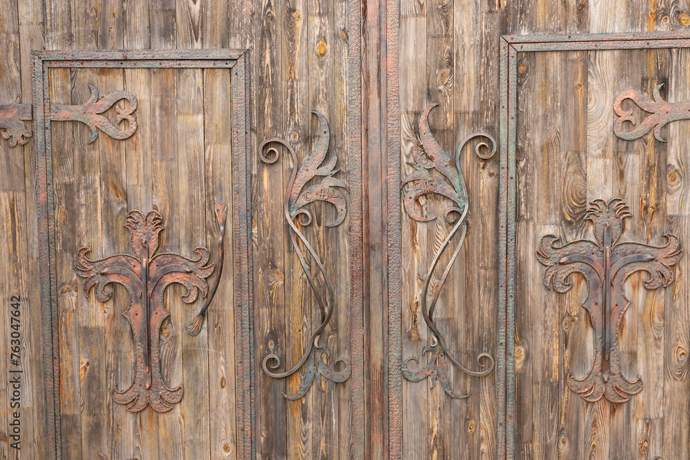 Antique wooden gate with wrought iron decorations. Antique wooden gate with wrought iron decorations.