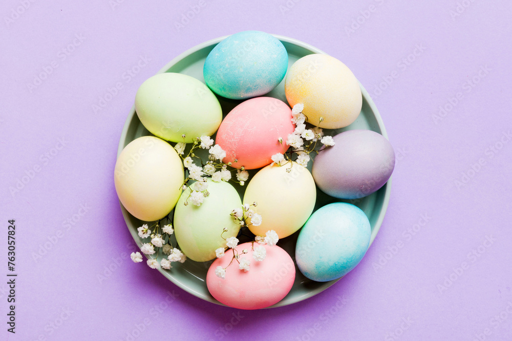 Happy Easter composition. Easter eggs in basket on colored table with gypsophila. Natural dyed colorful eggs background top view with copy space Happy Easter composition. Easter eggs in basket on colored table with gypsophila. Natural dyed colorful eggs background top view with copy space