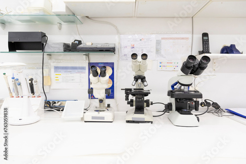 Lab bench with microscopes and various scientific tools for analysis.