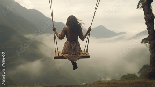 A woman enjoying nature on a swing in the mountains. Ideal for travel and outdoor lifestyle concepts