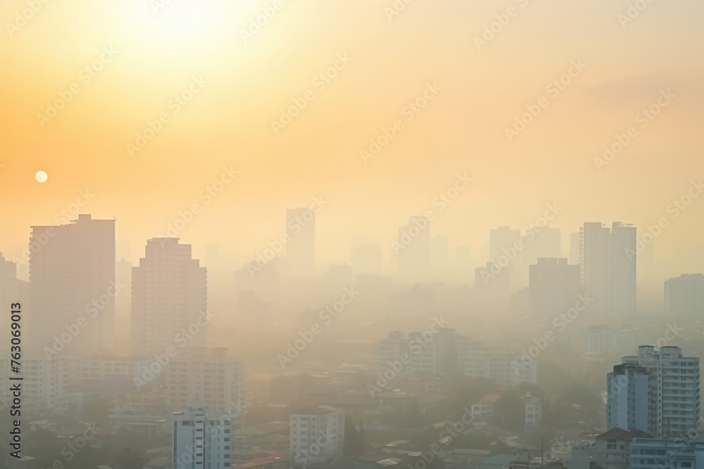 The sun rises over a cityscape covered in a haze, creating a moody and atmospheric urban morning. Hazy Sunrise over Urban Cityscape with Buildings