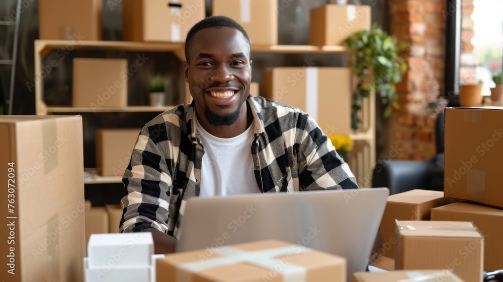 Small business owner is working on a laptop in the warehouse Small business owner is working on a laptop in the warehouse