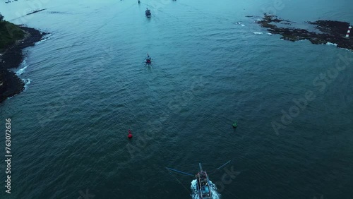 The fishing boat of Vietnamese fishermen is sailing into the port between the cliffs. Aerial cinematic shots for sensational, epic subjects.
