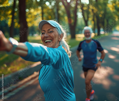 Happy senior woman stretching her arms while doing sport in the park with her husband, close up of arm and smiling face