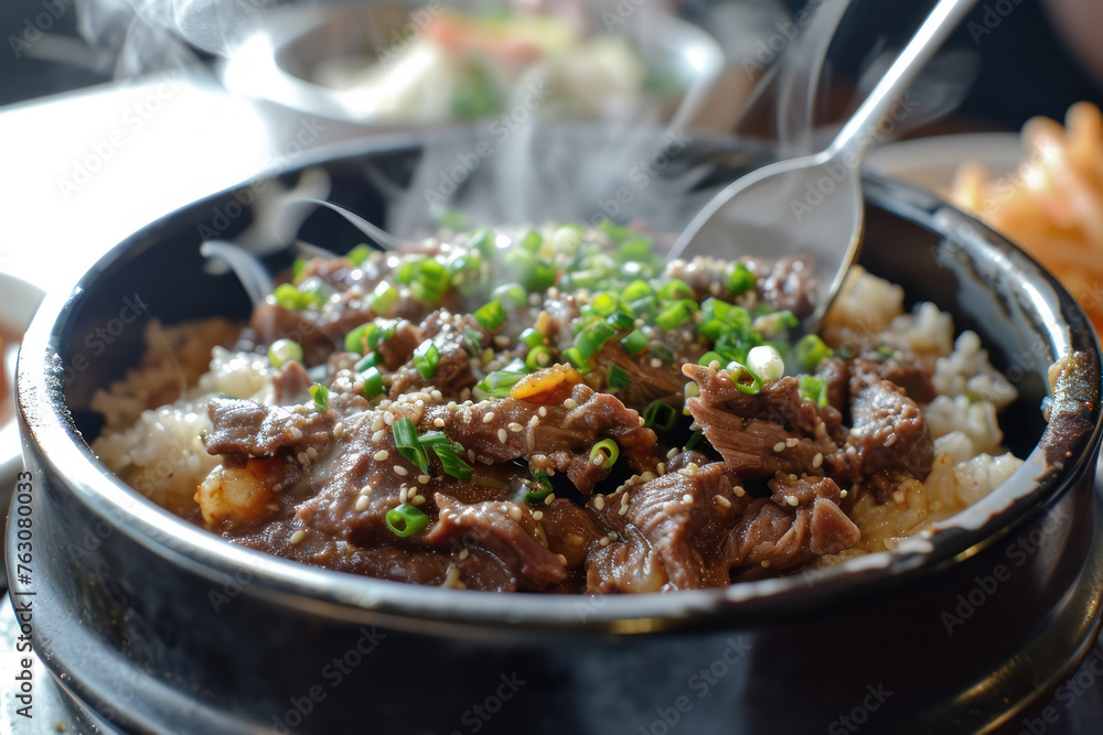 Korean Bulgogi Pork Rice on top with onsen york with someone put spoon in, hot steaming looking moist and very delicious Korean Bulgogi Pork Rice on top with onsen york with someone put spoon in, hot steaming looking moist and very delicious