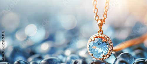 A blue and white gemstone pendant with a gold chain, Topaz