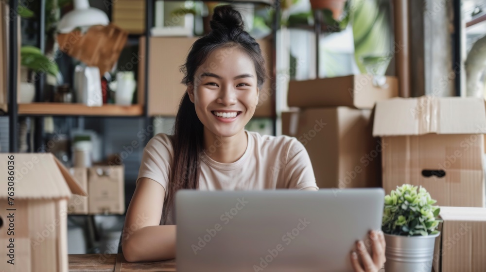 Small business owner is working on a laptop in the warehouse Small business owner is working on a laptop in the warehouse