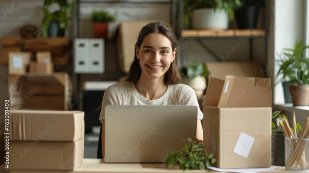 Small business owner is working on a laptop in the warehouse Small business owner is working on a laptop in the warehouse