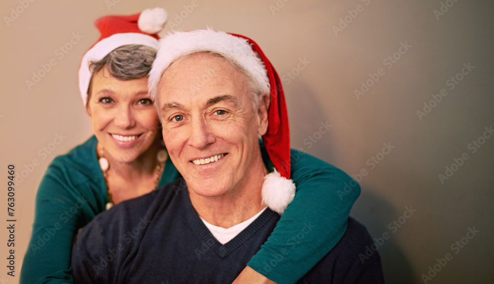 Christmas, portrait and senior couple with love, holiday and support together in home with romance. Happy, retirement and marriage with smile and hug in house with celebration and santa hat with joy Christmas, portrait and senior couple with love, holiday and support together in home with romance. Happy, retirement and marriage with smile and hug in house with celebration and santa hat with joy