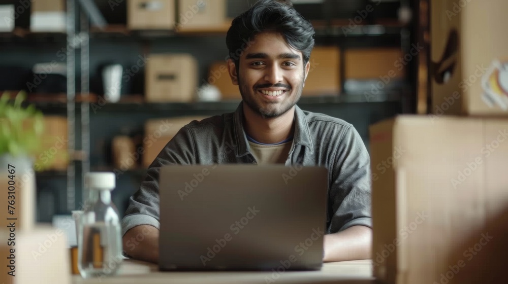 Small business owner is working on a laptop in the warehouse Small business owner is working on a laptop in the warehouse