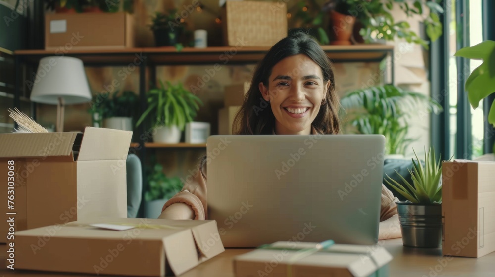 Small business owner is working on a laptop in the warehouse Small business owner is working on a laptop in the warehouse