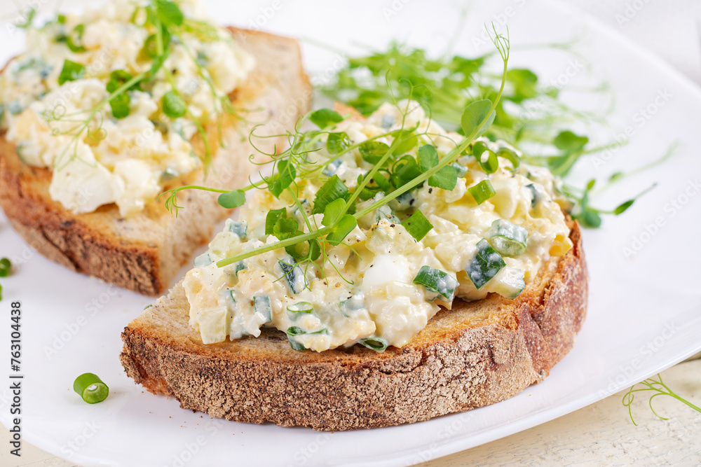 Delicious toast with pate boiled egg, cucumber and cream cheese on a white plate. Healthy eating, breakfast. Keto diet food. Tasty food. Delicious toast with pate boiled egg, cucumber and cream cheese on a white plate. Healthy eating, breakfast. Keto diet food. Tasty food.