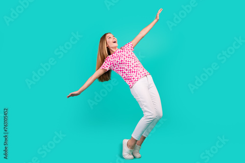 Full body photo of nice teen woman falling back spread hands wear trendy print pink clothes isolated on cyan color background