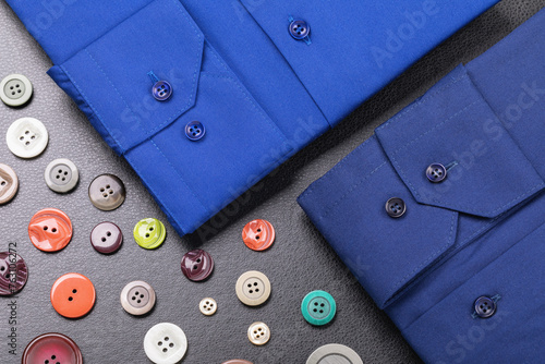 Cuffs of folded shirt sleeves and buttons on a dark background, concept on the theme of selecting buttons for clothes