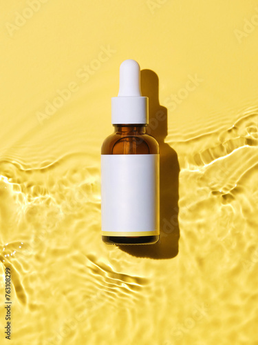 minimalistic image featuring a brown glass dropper bottle with a blank white label against a textured yellow backdrop.