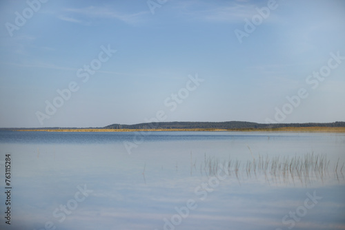 blue water  blue sky  yellowed grass on the lake  early autumn sunset on the lake  reeds on the lake 