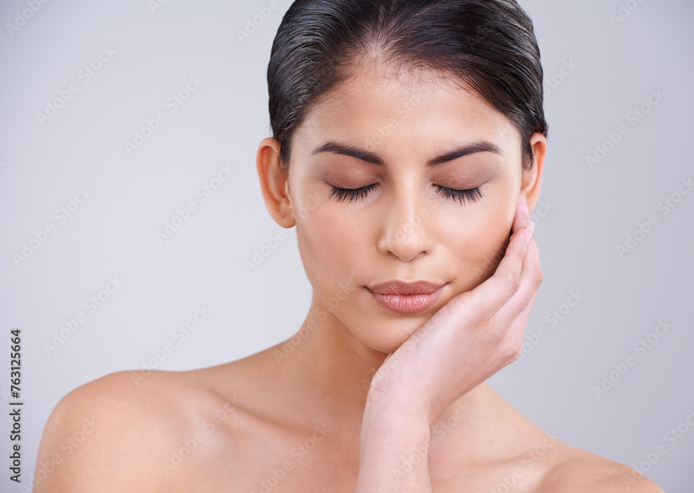 Woman, relax and face with skincare, cosmetics or facial treatment on a gray studio background. Young female person, brunette or model with smile in satisfaction for beauty, makeup or spa on mockup Woman, relax and face with skincare, cosmetics or facial treatment on a gray studio background. Young female person, brunette or model with smile in satisfaction for beauty, makeup or spa on mockup