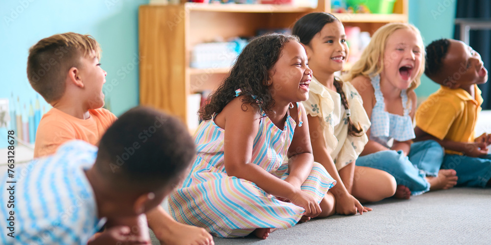 Line Of Smiling Primary Or Elementary School Students Sitting On Floor During Classroom Lesson Line Of Smiling Primary Or Elementary School Students Sitting On Floor During Classroom Lesson