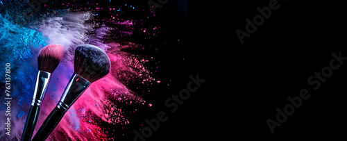 Makeup brushes with dynamic powder burst on black background with copy space.